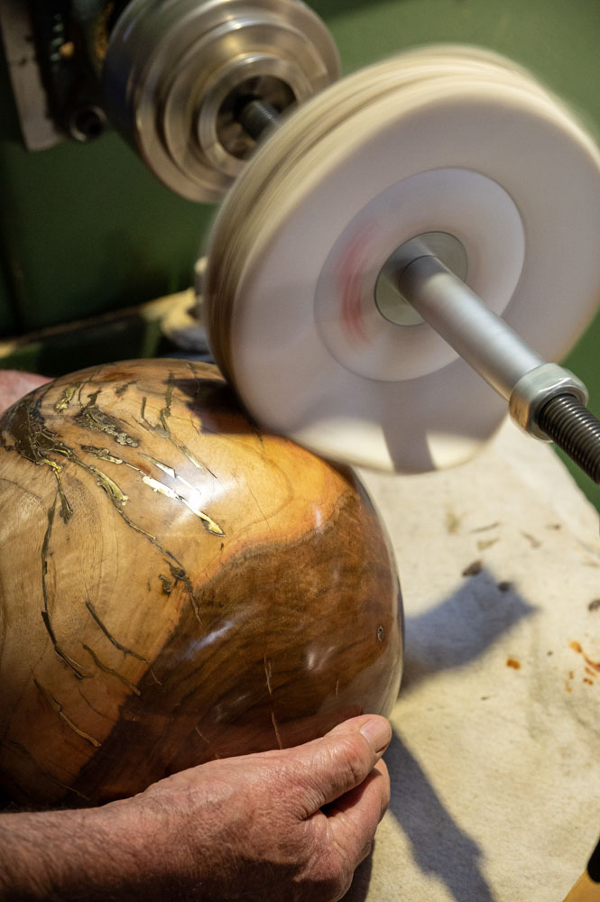 photo gros plan montrant la phase de cirage des oeufs en bois