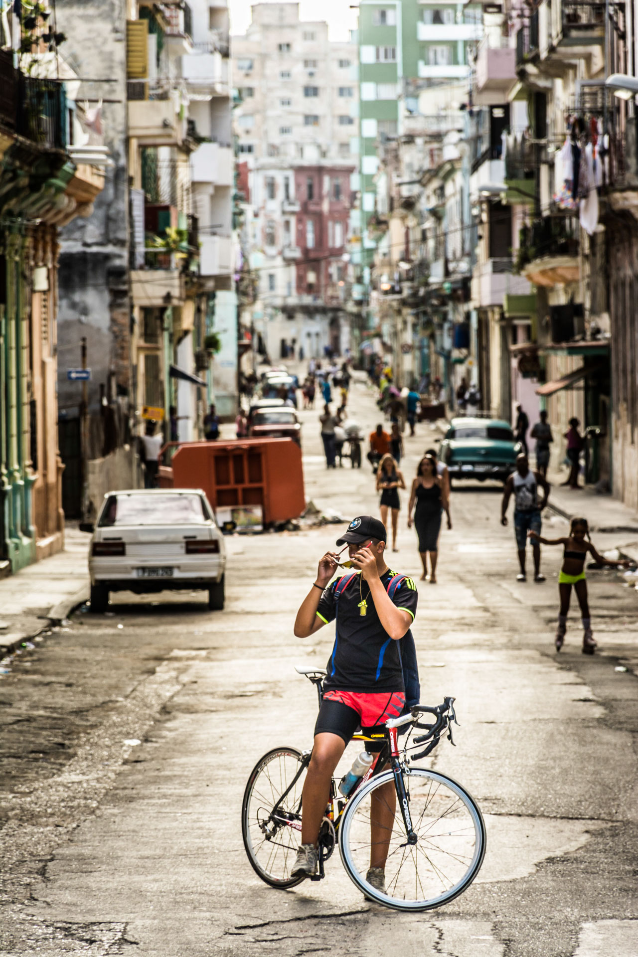 photo de paysage de d'un cycliste remettant ses lunettes au bout d'une rue de La Havane